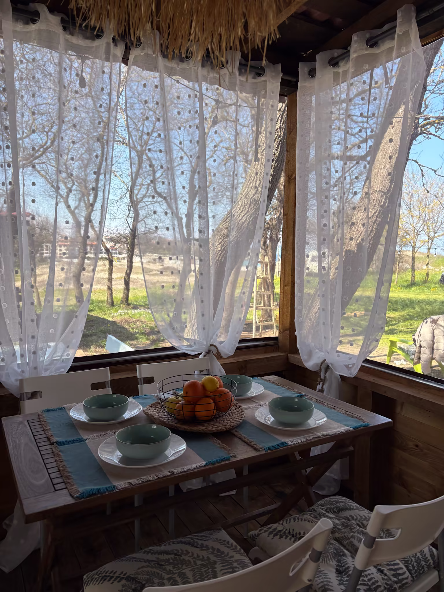 Трапезарията на ELYSIUM I — закуска с изглед през завесите към дърветата